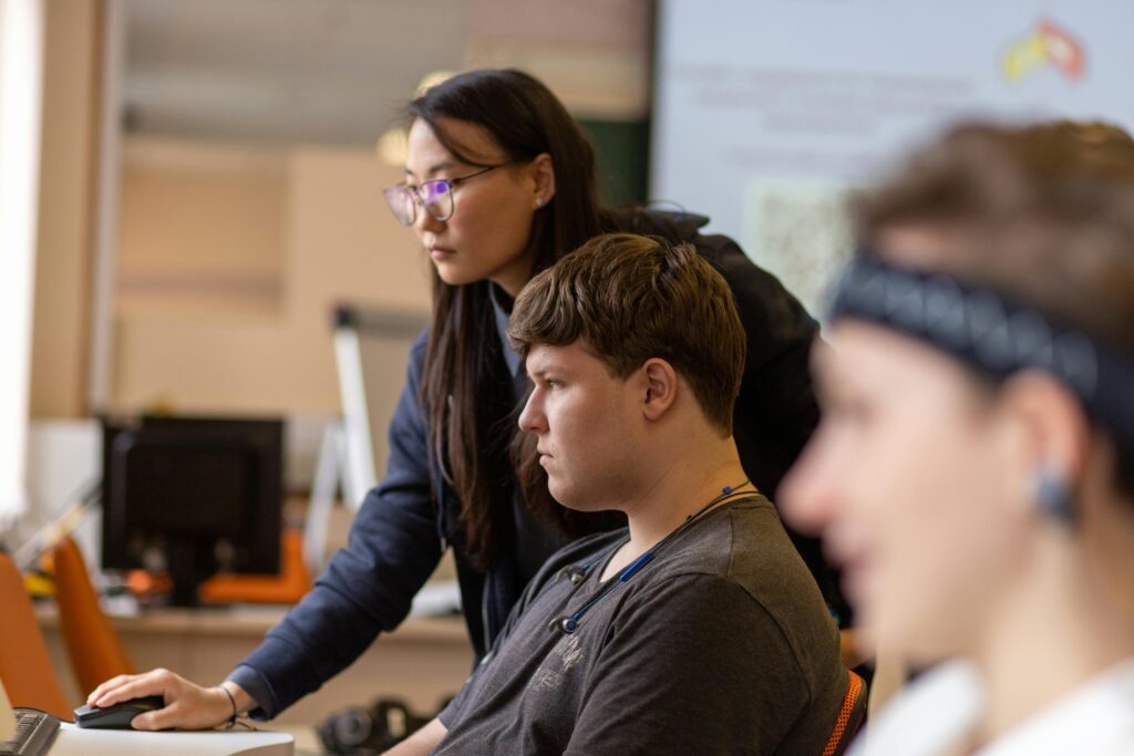 Students working together on computers in a classroom, showcasing diversity and teamwork.
